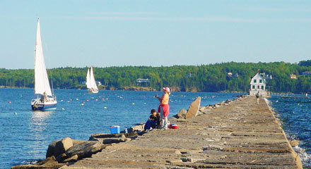 fishermen and sailboats beside breakwater