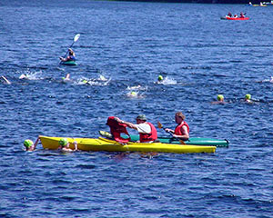 kayakers handing out life jackets to tired swimmers